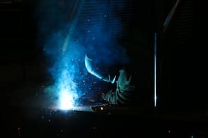 Vibrant sparks fly during welding in a busy workshop, showcasing intense craftsmanship.